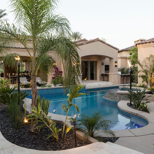 Idee per una piscina naturale tropicale personalizzata di medie dimensioni e dietro casa con una vasca idromassaggio e pavimentazioni in cemento