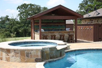 Example of a large mountain style backyard stone and custom-shaped pool house design in New Orleans