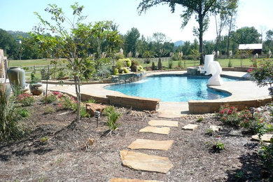 Modelo de piscinas y jacuzzis alargados clásicos grandes a medida en patio trasero con suelo de baldosas