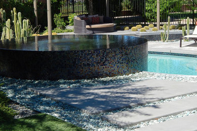 Esempio di una piscina a sfioro infinito minimal personalizzata di medie dimensioni e dietro casa con una vasca idromassaggio e piastrelle