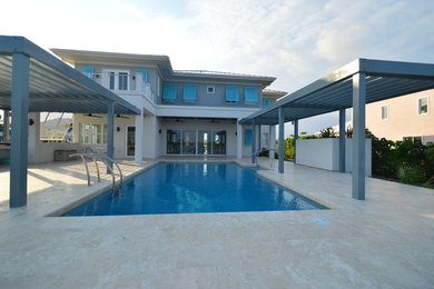 Example of a trendy stone and rectangular lap pool design in Other