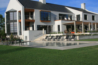 Imagen de piscinas y jacuzzis alargados contemporáneos de tamaño medio rectangulares en patio trasero con adoquines de piedra natural