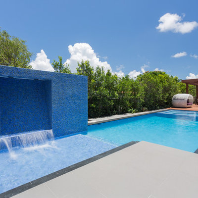 Inspiration for a mid-sized contemporary backyard stamped concrete and rectangular lap pool fountain remodel in Miami