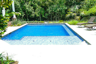Стильный дизайн: прямоугольный бассейн среднего размера на заднем дворе в современном стиле с покрытием из каменной брусчатки - последний тренд