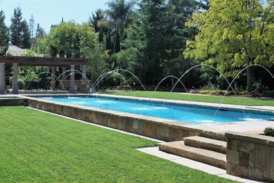 Pool fountain - traditional backyard rectangular lap pool fountain idea with decking
