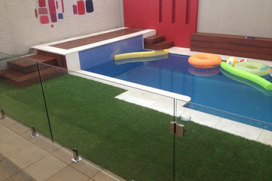 Foto de piscina alargada actual de tamaño medio en patio trasero