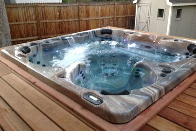 Mid-sized elegant backyard hot tub photo in Denver with decking