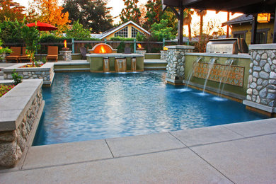 Idee per un'ampia piscina personalizzata dietro casa con pavimentazioni in cemento