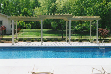 Imagen de piscina tradicional renovada de tamaño medio rectangular en patio trasero con losas de hormigón