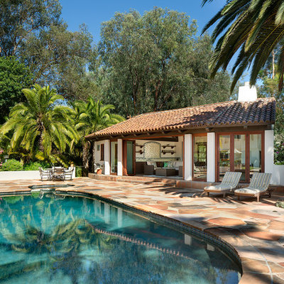 Example of a southwest backyard stone and round natural pool house design in San Diego