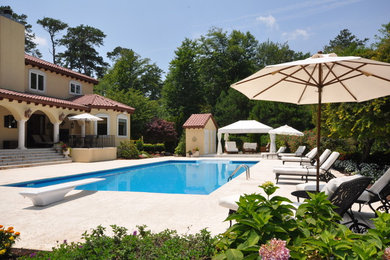 Diseño de piscina alargada mediterránea extra grande rectangular en patio trasero con adoquines de hormigón
