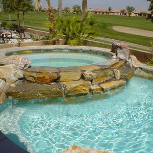 Esempio di una piccola piscina naturale tropicale rotonda con una vasca idromassaggio e pedane