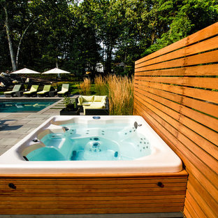 Photo of a mid-sized contemporary rectangular pool in Boston with natural stone pavers.