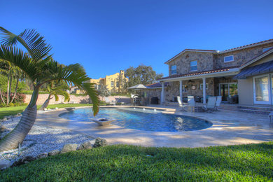 Immagine di una piscina naturale classica personalizzata di medie dimensioni e dietro casa con fontane e pavimentazioni in pietra naturale