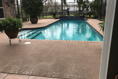 Modelo de piscina con fuente clásica de tamaño medio en patio trasero con adoquines de piedra natural