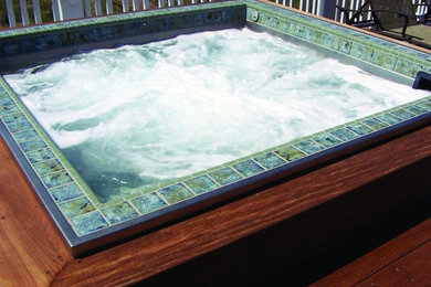 Example of a small backyard rectangular aboveground hot tub design in San Diego with decking