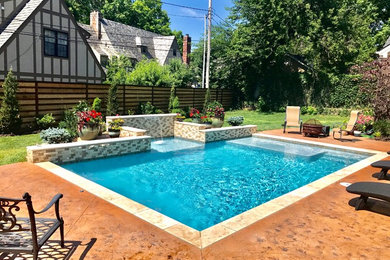 Ejemplo de piscina alargada contemporánea rectangular en patio trasero con losas de hormigón