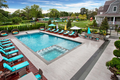 Large trendy backyard concrete paver and rectangular pool photo in New York