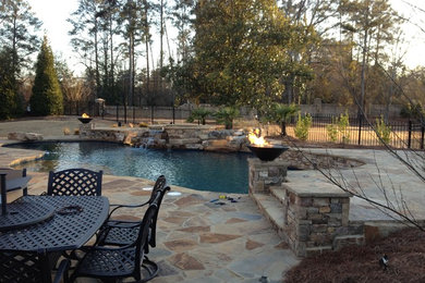 Example of a large classic backyard stone and custom-shaped lap hot tub design in Atlanta