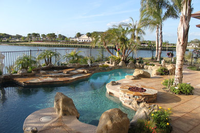 Inspiration for a small tropical backyard concrete paver and custom-shaped natural hot tub remodel in Orlando