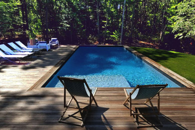Example of a mid-sized minimalist backyard rectangular pool design in New York with decking