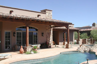 Modelo de piscinas y jacuzzis de estilo americano grandes a medida en patio trasero con suelo de hormigón estampado