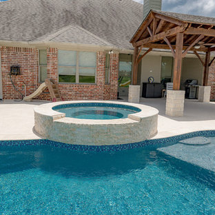Esempio di una piscina naturale chic a "C" di medie dimensioni e dietro casa con una vasca idromassaggio e pedane