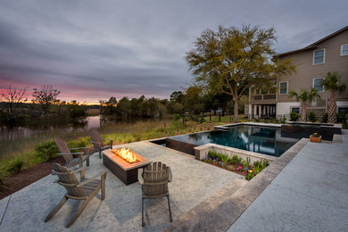 Inspiration for a mid-sized contemporary backyard stone and custom-shaped infinity hot tub remodel in Charleston