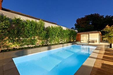 Идея дизайна: прямоугольный, спортивный бассейн на заднем дворе в стиле модернизм с настилом
