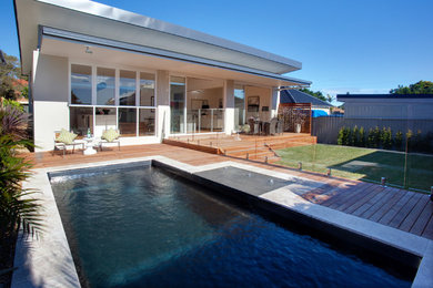Foto de piscina contemporánea de tamaño medio rectangular en patio trasero con entablado