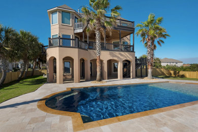 Mid-sized elegant backyard stamped concrete and custom-shaped natural pool photo in Miami