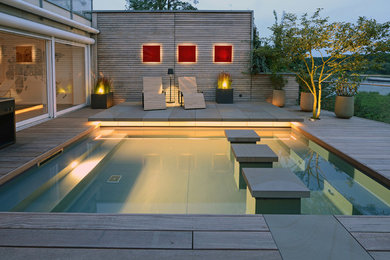 Mittelgroßer Moderner Pool neben dem Haus in rechteckiger Form mit Dielen in Köln