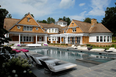 Design ideas for a beach style swimming pool in New York with natural stone paving.