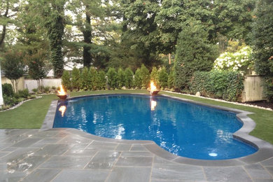 Inspiration for a medium sized traditional back custom shaped swimming pool in New York with a water feature and natural stone paving.