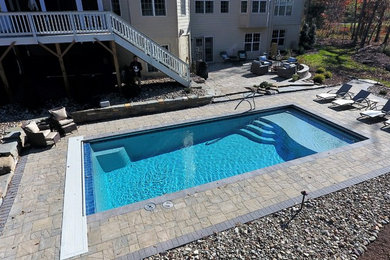 Inspiration for a mid-sized rustic backyard concrete paver and rectangular pool remodel in DC Metro