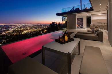 Hot tub - mid-sized modern backyard tile and custom-shaped infinity hot tub idea in Los Angeles
