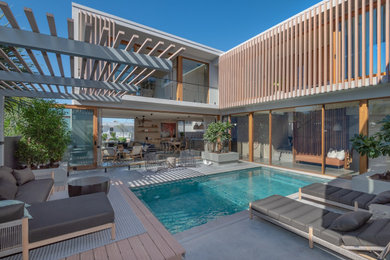 This is an example of an expansive coastal back rectangular lengths swimming pool in Sunshine Coast with decking.