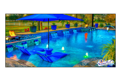 Pool - huge tropical backyard custom-shaped pool idea in Tampa with decking