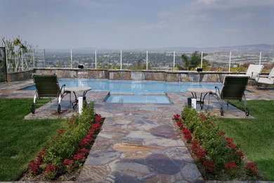 Inspiration for a mid-sized timeless backyard stone and rectangular lap hot tub remodel in Orange County