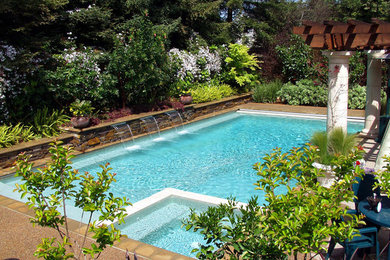 Идея дизайна: большой прямоугольный, спортивный бассейн на заднем дворе в современном стиле с фонтаном и покрытием из гранитной крошки