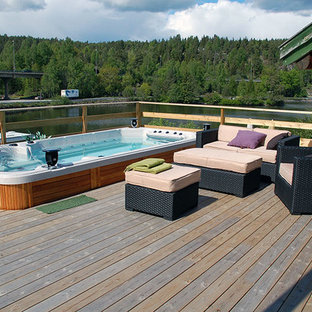 Immagine di una piscina fuori terra country rettangolare di medie dimensioni e dietro casa con una vasca idromassaggio e pedane