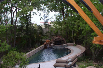 Example of a backyard concrete and custom-shaped hot tub design in Austin