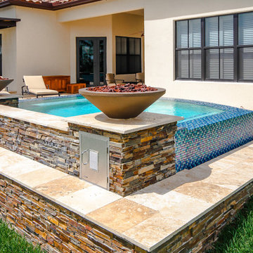 Swim Spa With Custom Fire Bowls and Outdoor Kitchen in Cooper City, Florida