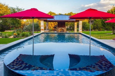 Modelo de piscina natural moderna grande rectangular en patio trasero con adoquines de hormigón