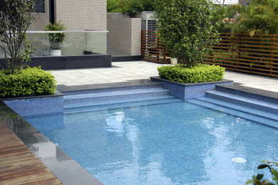 Inspiration for a large contemporary backyard rectangular pool remodel in Houston with decking