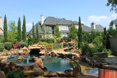 Foto de piscina rústica redondeada en patio trasero con adoquines de piedra natural