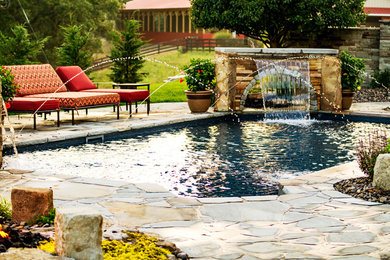 Foto de piscina con fuente natural ecléctica rectangular en patio trasero con adoquines de piedra natural