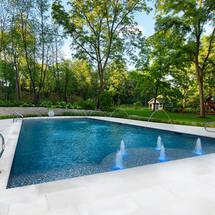 Design ideas for a large traditional backyard rectangular lap pool in Chicago with a water feature and tile.