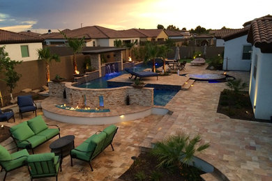 Photo of a large world-inspired back custom shaped swimming pool in Phoenix with decking.