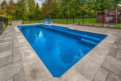 Inspiration for a mid-sized contemporary backyard brick and rectangular pool remodel in Ottawa